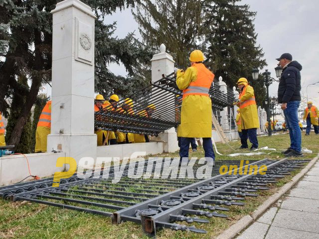 Workers begin removing the iron fence around the Government building