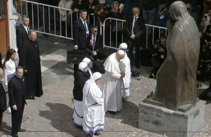 Pope Francis prays before Mother Teresa statue