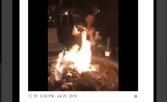 Macedonian man filmed chomping on a cigar, mumbling God bless America as he burns dollar bills