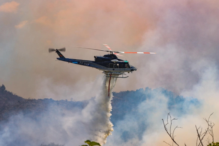 Two air tractors join the battle against the fires at Serta Mountain by an army helicopter